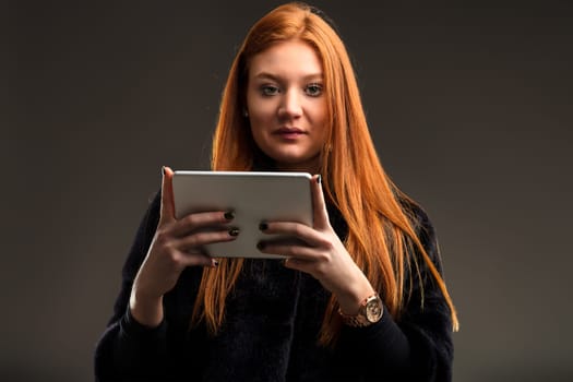 Tech-savvy woman with auburn hair effortlessly navigates through the latest apps on her device