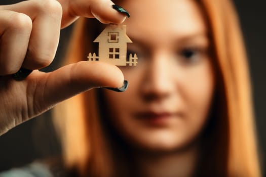 Young lady with striking hair color holding a representation of domesticity