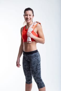 Standing portrait of a young woman with faintly East-Asian features, in an orange sports top and tight workout pants, showing her flat and muscular belly. She's burning fat by exercising in the gym, p