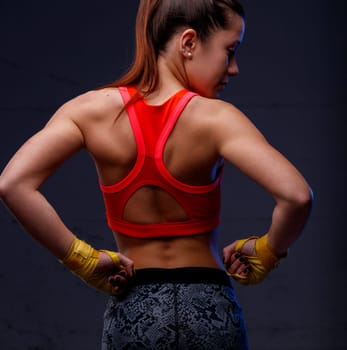 Muscular woman kick-boxer, appreciating her firm body. Unafraid to embrace words and bodies, confronting anyone with her gaze