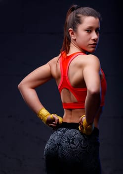 Kick-boxing woman, proud of her muscular back and firm body. Embraces diversity, challenges norms, unafraid of confrontation