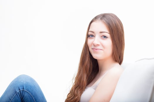 Relaxed at home, the woman's contented expression speaks to a moment of serene repose on a cozy sofa