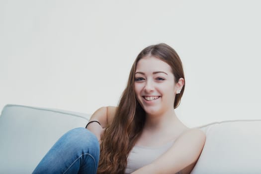 Comfortable in her own space, the young lady's casual pose and soft gaze suggest a peaceful ease