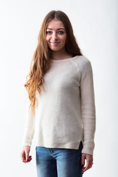 Casual elegance captured in a young woman's stance, with a soft smile and confident blue eyes, dressed in a knit sweater