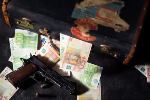 a close up of colt 1911, ammos and money, suitcase on background