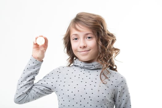 A polka-dotted girl displays a golden coin, symbolizing one euro and financial awareness