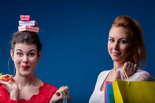 Shopping trip takes a whimsical turn with one woman balancing boxes on her head