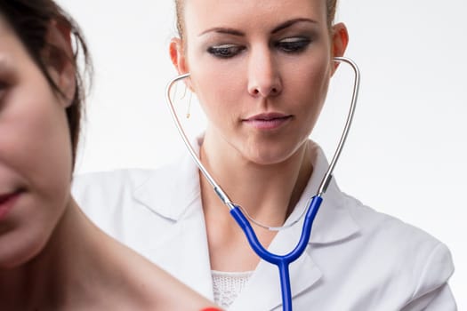 Healthcare professional attentively uses a stethoscope on a patient, focusing closely