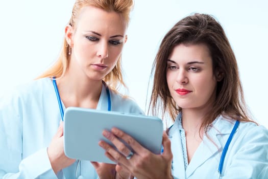 Female healthcare workers review digital data, expressing concern and concentration