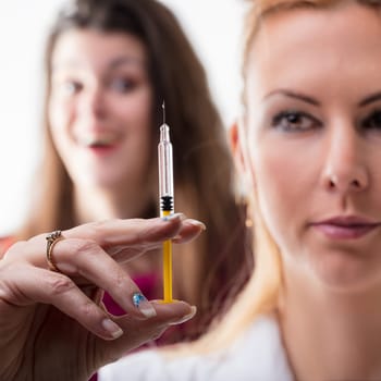 Syringe examination by a healthcare worker, observed by an apprehensive individual