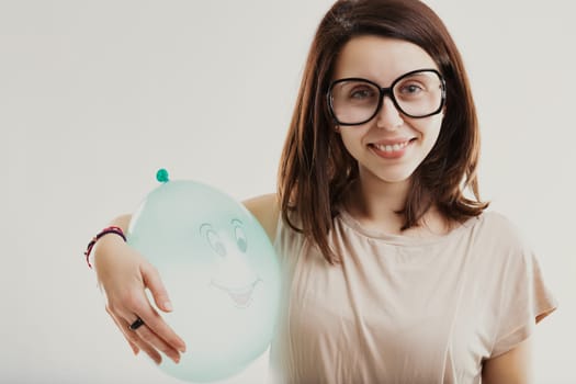 Happy balloon complements the joyful expression of a bespectacled young woman