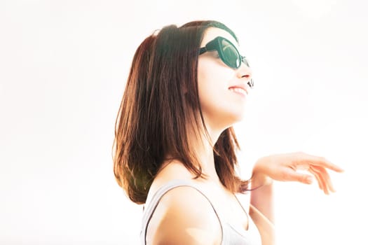 Smiling woman in sunglasses looks upwards, her optimism reflected in her upward gaze