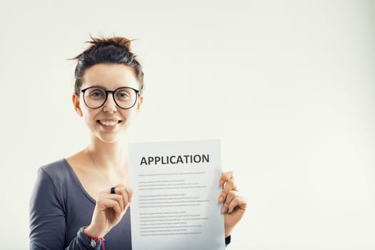 optimistic woman proudly presents an application form, symbolizing a step towards new beginnings