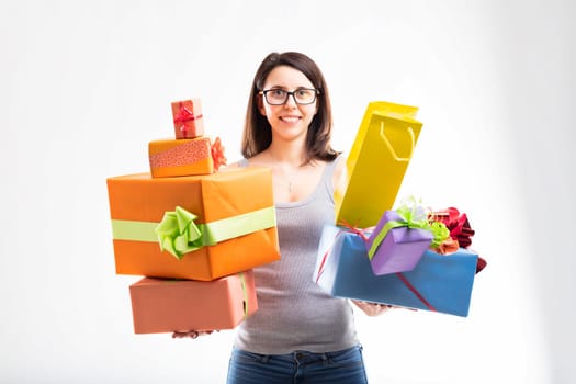 Cheerful and ready to celebrate, she balances several wrapped presents with festive ribbons