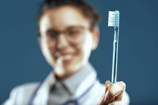 Dental professional presents a toothbrush, focus sharp on oral hygiene with a blurred backdrop