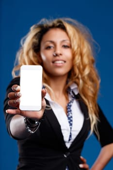 Stunning black woman, blonde mane, proudly shows empty smartphone screen (for your copyspace). Wears chic dress, nose piercing hand on hip expression of pride
