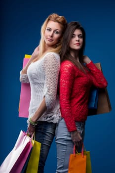 Retail therapy concludes with two women showcasing their bounty of shopping bags