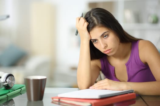 Frustrated student complaining at home trying to memorize lesson from notebook