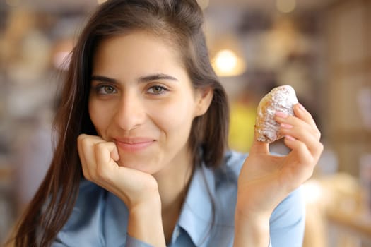 Portrait of a satisfied restaurant customer holding bakery looking at you
