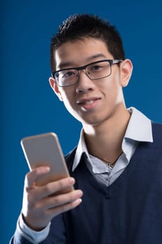 'Smiling Asian man with a smartphone. Wearing glasses, a shirt, and a sweater, has short hair. Uses mobile for apps, internet, messages, news, and artificial intelligences