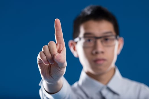 Hold on, objection! Blurred Asian man in the background raises his index finger (in sharp focus) indicating either refusal or a request to speak and criticize or object. Freedom of speech, critique, e