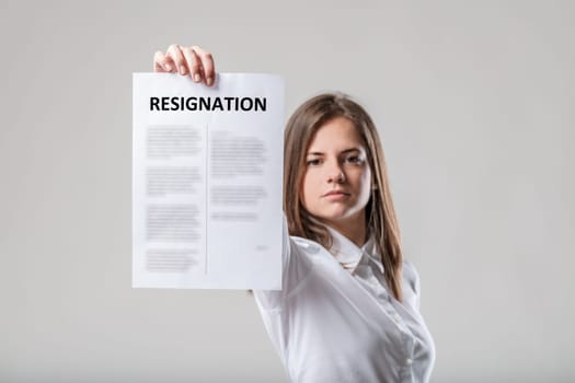 Woman, upright posture, displays 'resignation' sign. Reminder of great-resignation, business reciprocity. Wearing white brown hair