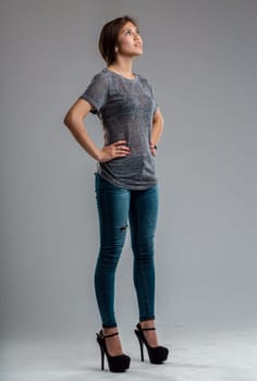 Three-quarter-length portrait of a full-length girl with her hands on her hips and sky-high heels the heels slender her so much and because she is looking up she looks like a super heroine ready to fl