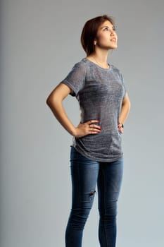 Poised and reflective, the womans upward gaze matches her laid-back yet fashionable outfit