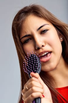 In a spontaneous performance, the hairbrush becomes an instrument of joy and music