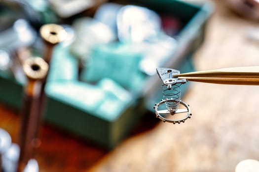 Watches, gears, springs, metal mechanisms, jewels, and wood on a craftsman's table