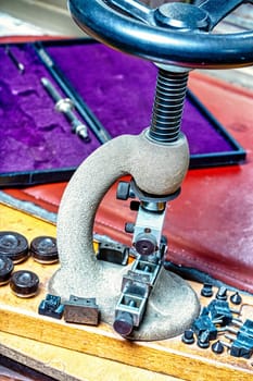 A craftsman's table laden with intricate watch components. The steampunk ambiance, the detailed focus and the shallow depth of field amplify the precision and skill in watchmaking