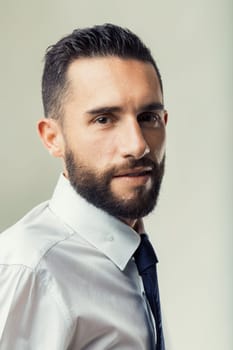 Confident businessman with a well-groomed beard poses in semi-profile