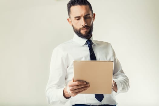 Businessman examines a digital tablet, contemplating the information within