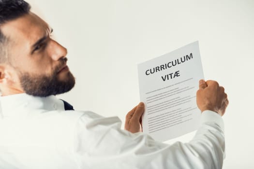 businessman reads a CV that bewilders him a bit : he considers it inadequate, poorly written, with ignorant language that hides competence, if there is any