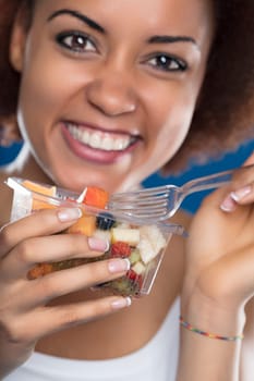 Joyful woman enjoys a fresh, colorful fruit salad, a moment of pure delight