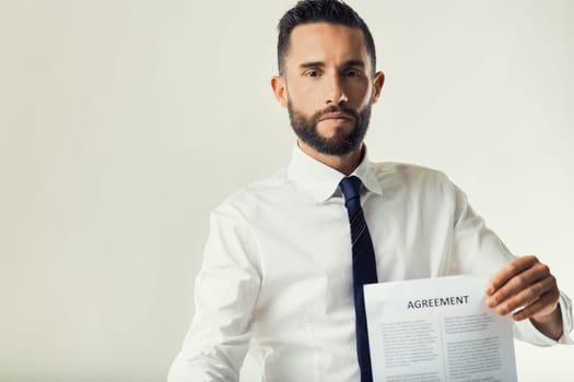 Man in business attire displays a document, indicating a moment of negotiation