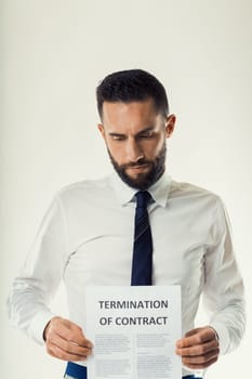 Disappointed businessman examines the terms of a contract termination, considering his next steps