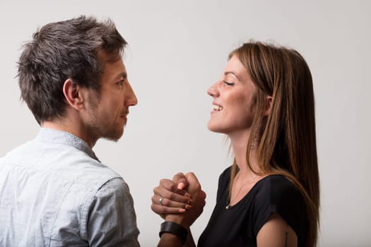Man and woman, playfully defiant, engage in arm wrestling, embodying the dichotomy of friends and lovers, rivals and competitors, but always with a sense of fairness and fun