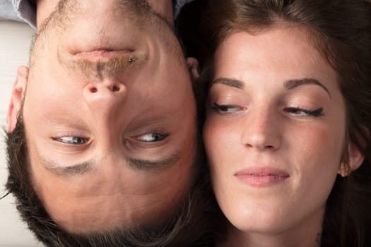 From above, the faces of two young lovers touch, upside down to each other. They gaze in erotic and sentimental anticipation, a mix of promises and doubts underlining the intricacies of love
