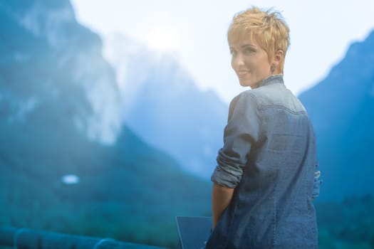 Surrounded by the grandeur of mountains, she pairs her stylish denim with cutting-edge technology