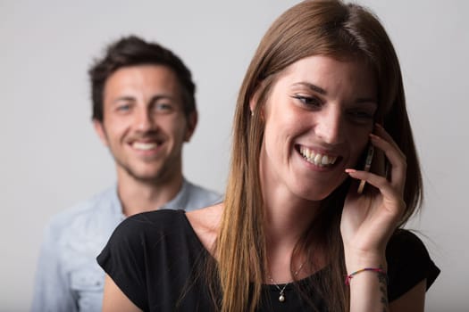 A woman on a phone call takes the foreground, with a blurred, suspicious young man in the backdrop. It insinuates betrayal, jealousy, love, stormy relations - the notion of a man's jealousy, frustrati