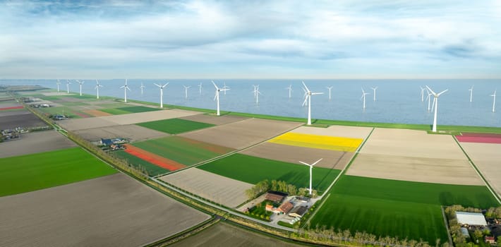 aerial view of a beautiful landscape filled with colorful tulips and wind turbines