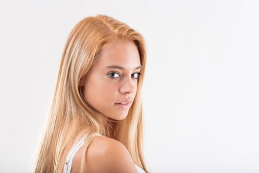 Young woman with blonde hair glances sideways, expression mingled with curiosity and pensiveness