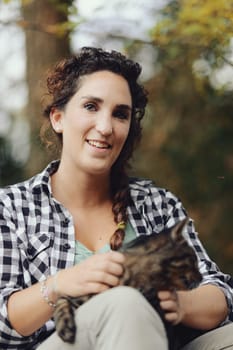 Portrait of feline with human. Portrait of woman with cat. In the woods a woman and a cat meet and caresses are bestowed. Who enjoys it more? Let's find out.