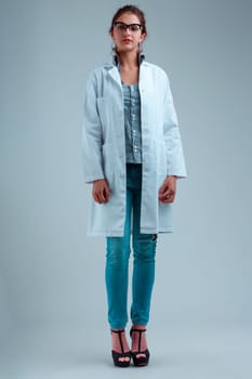 Woman in white coat and glasses, dressed stylishly with jeans, heels, striped blouse. Full-length portrait, displaying a listening and waiting expression