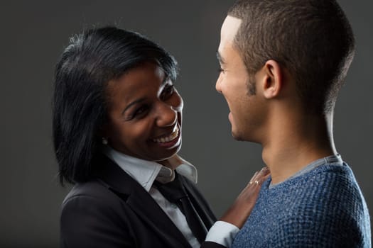 Her professional attire contrasts with his relaxed look, yet their jovial connection bridges any divide