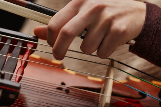 musician's intimate interaction with the Nyckelharpa, showcasing the complexity and beauty of this historical instrument