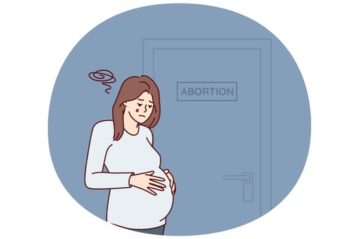 Upset pregnant woman stands near door with abortion sign needs psychologist after making difficult decision. Girl crying wants to terminate pregnancy due to unwanted insemination
