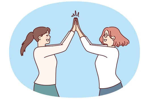 Two happy women rejoice high five greet each other after long-awaited meeting. Positive girls in casual clothes are happy to know about next vacation and joint summer trip