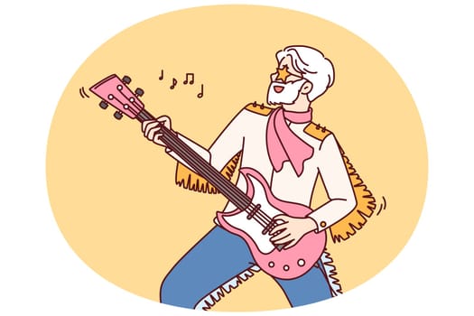 Elderly man playing music on guitar performing solo concert in front of audience at rock party. Gray-haired male guitarist in extravagant clothes performs rock composition on guitar